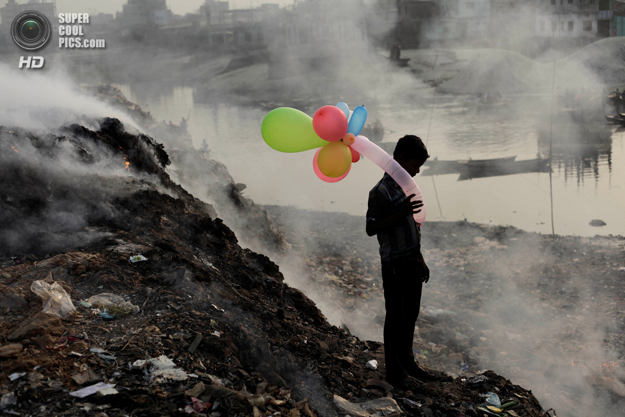 &laquo;Поощрительный приз&raquo;. Мальчик с надувными шариками на берегу Буриганги. Эта река считается одной из самых загрязнённых на планете. Место съемки: Барнгладеш. Дакка. (Andrew Biraj/National Geographic Photo Contest)